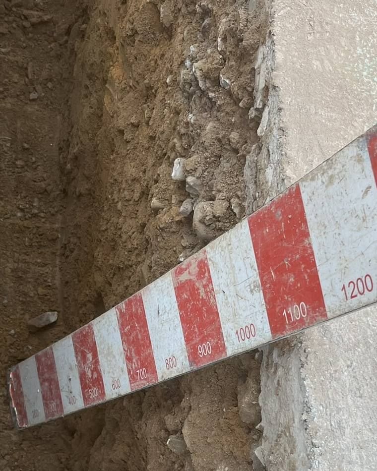 Depth staff held in a trench reading past 1,100 mm