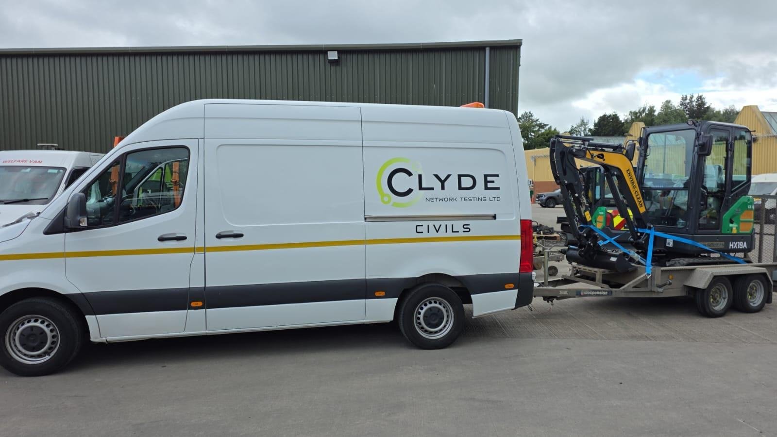Van towing a mini excavator on a plant trailer